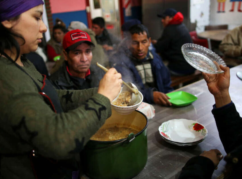 A volunteer serves stew at a soup kitchen in Buenos Aires